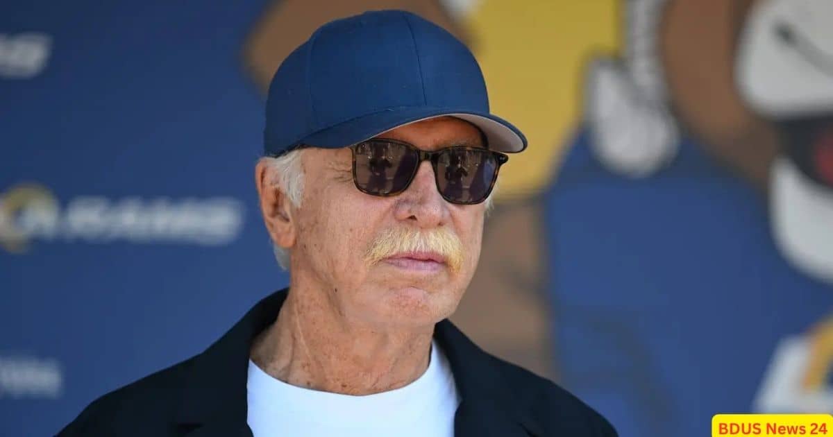 Billionaire sports owner Stan Kroenke pictured wearing a blue cap during a major franchise announcement.