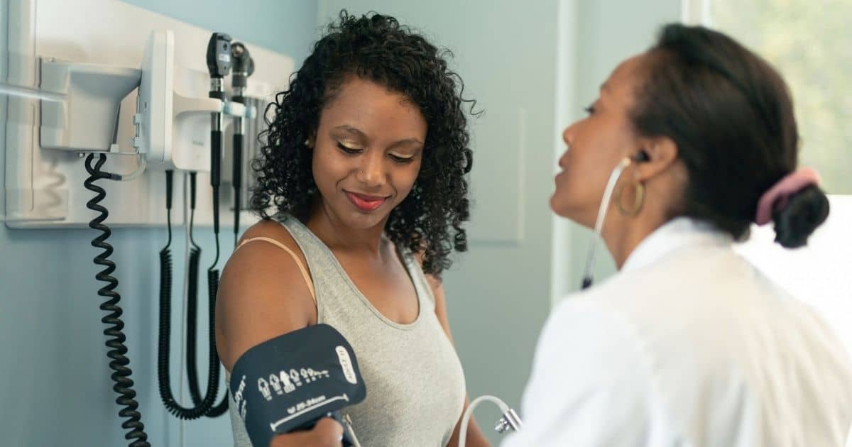 Doctor checking a patient's blood pressure during a physical exam