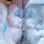 Researchers in protective suits working in a specialized laboratory environment, relating to the Siberian plague institute safety investigation.